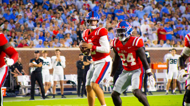 Jaxson Dart and Ulysses Bentley red jersey and blue helmet